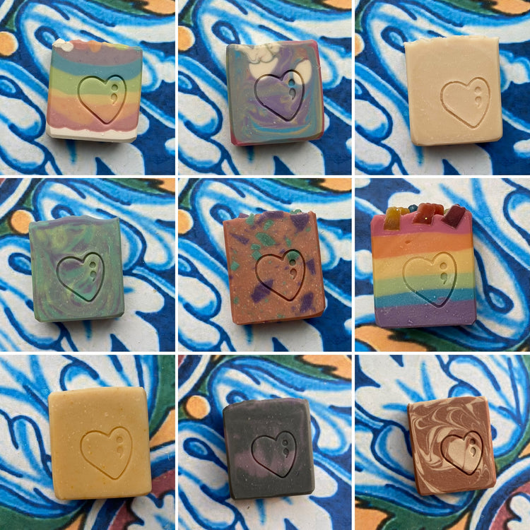 Collection of square soap bars with heart designs on a colorful abstract background