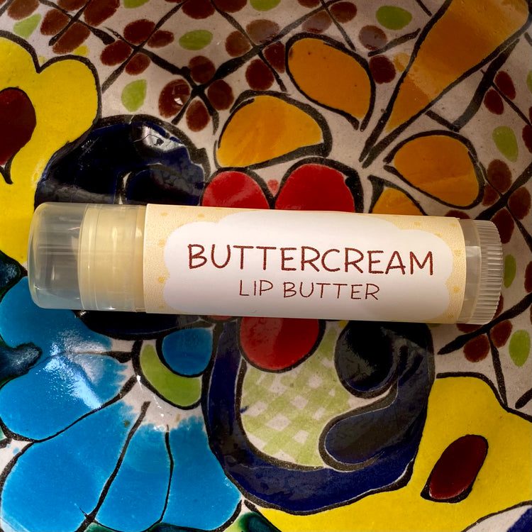 A tube of buttercream lip butter on a colorful background