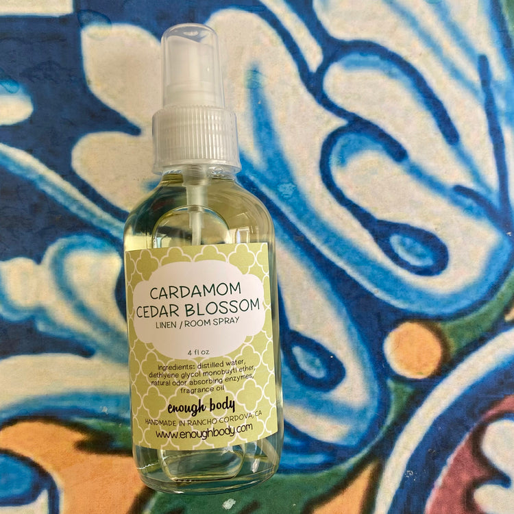 Cardamom Cedar Blossom linen/room spray bottle with a colorful patterned background