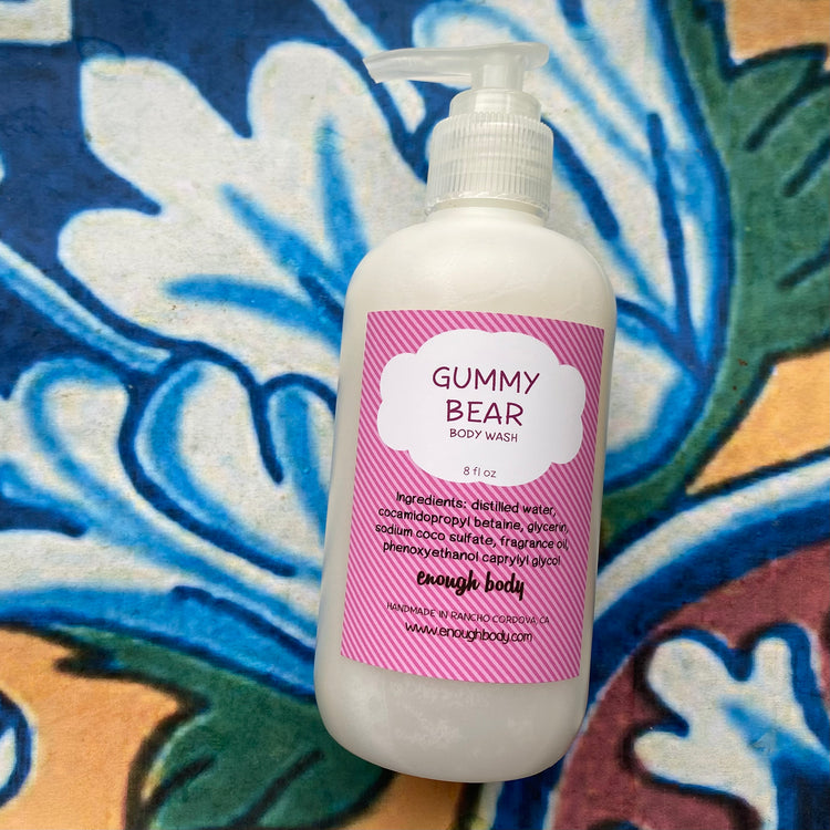 Gummy Bear body wash bottle with pink label on a colorful patterned background