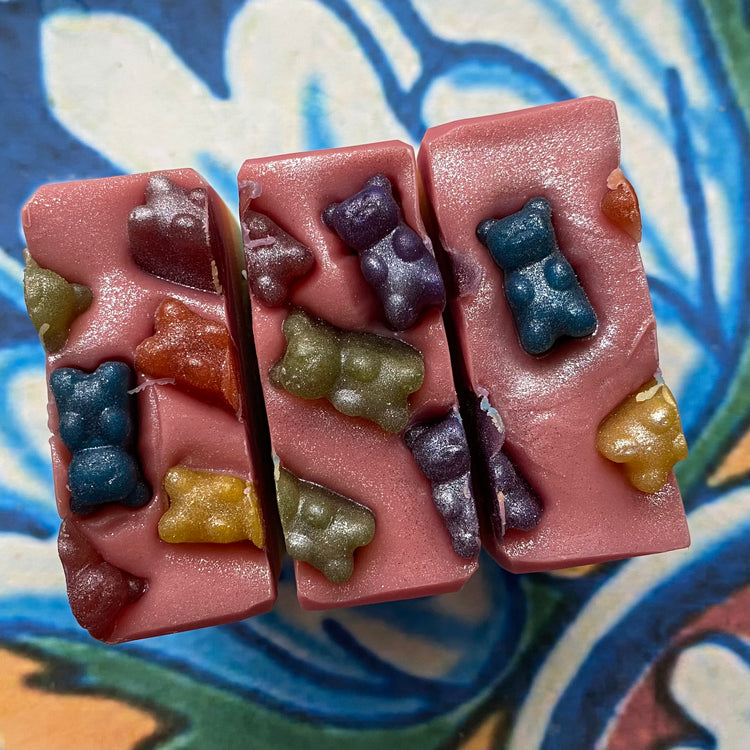 Colorful gummy bear soap shapes on top of rectangular soap bars