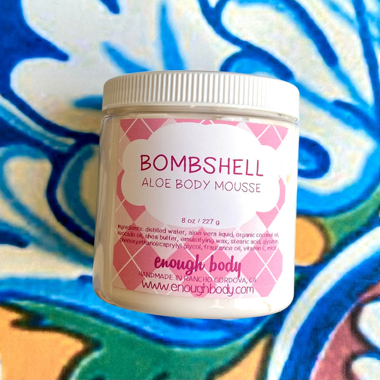 Jar of bombshell Aloe Body Mousse on a colorful background