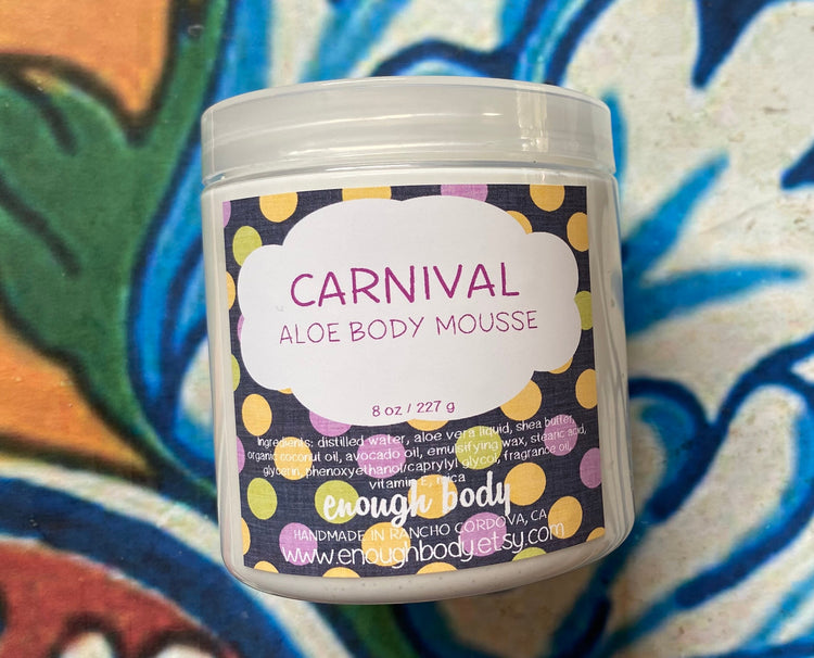 A jar of Carnival Aloe Body Mousse with a colorful label featuring polka dots and the brand's logo.