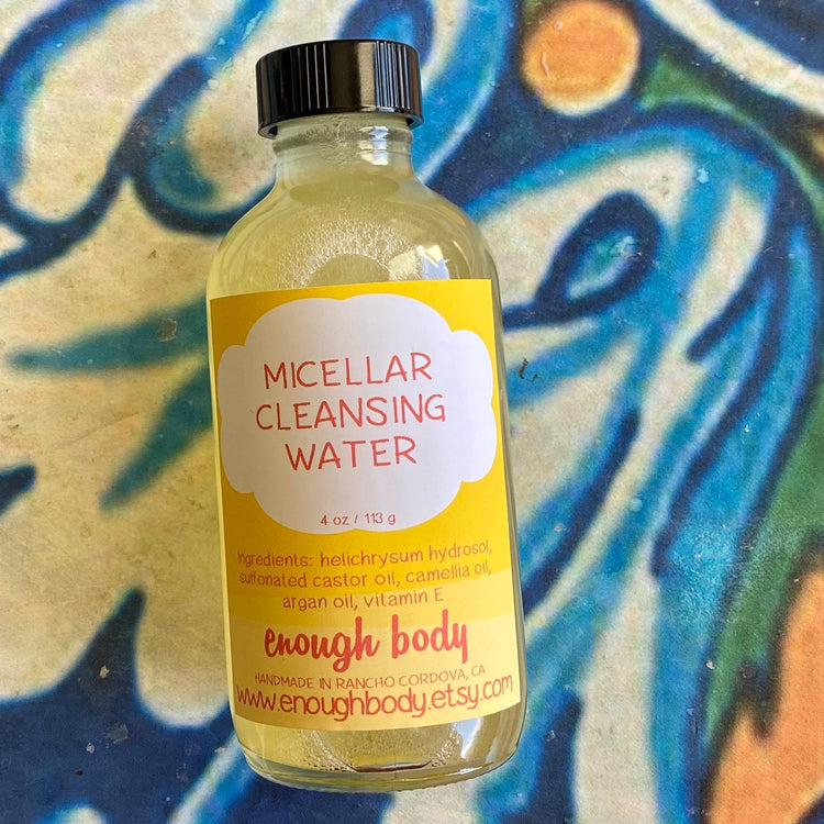 Bottle of micellar water with yellow label on a colorful abstract background
