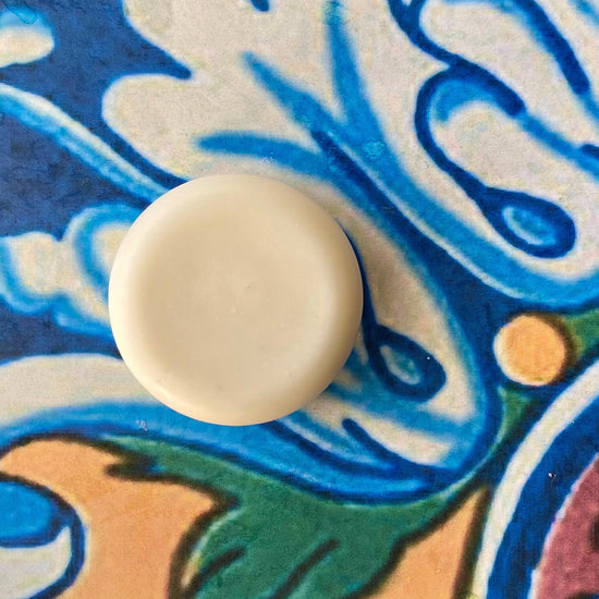 A solid conditioner bar on a colorful patterned background.