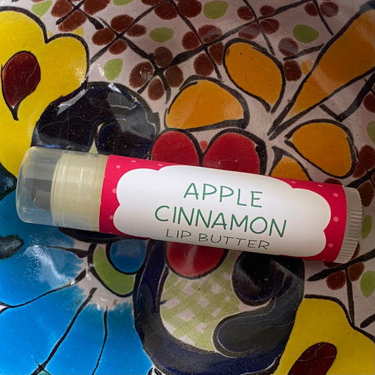 Apple cinnamon lip butter with a colorful floral background