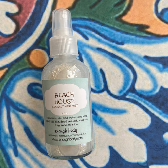 Beach House sea salt hair mist bottle on a colorful background