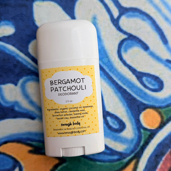 Deodorant stick with Bergamot Patchouli label on a colorful fabric background