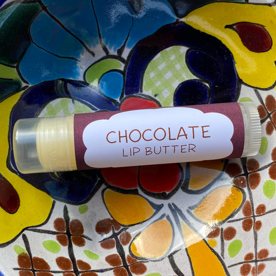 A tube of chocolate lip butter on a colorful background