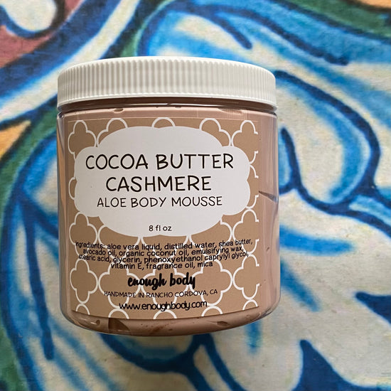 Jar of Cocoa Butter Cashmere Aloe Body Mousse on a colorful background