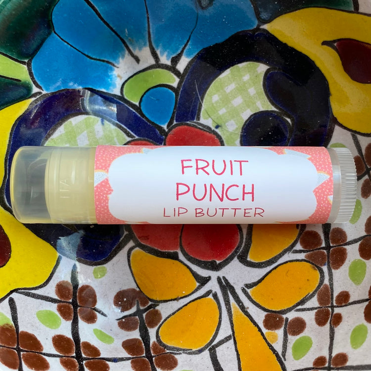Lip butter labeled 'Fruit Punch' on a colorful floral plate