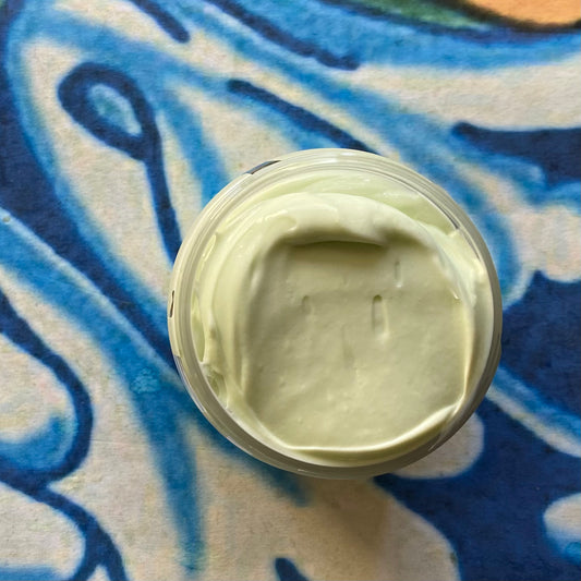Jar of green cream on a textured blue and white background
