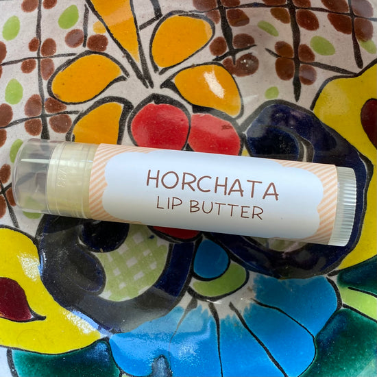 Lip butter labeled 'Horchata' on a colorful ceramic plate
