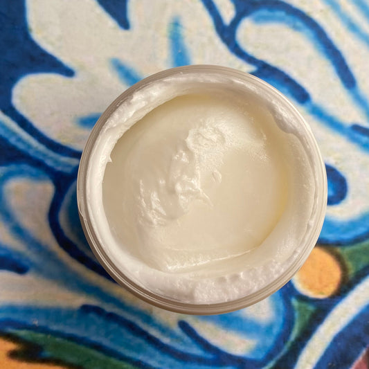 Jar of white cream on a colorful patterned surface