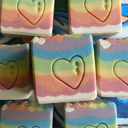Stack of colorful soap bars with heart designs on a blue background