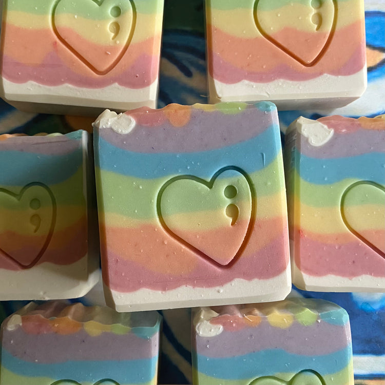 Stack of colorful soap bars with heart designs on a blue background