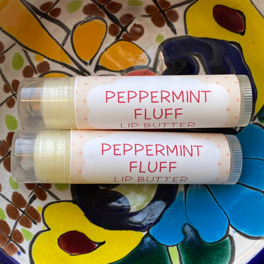A tube of peppermint fluff lip butter on a colorful background