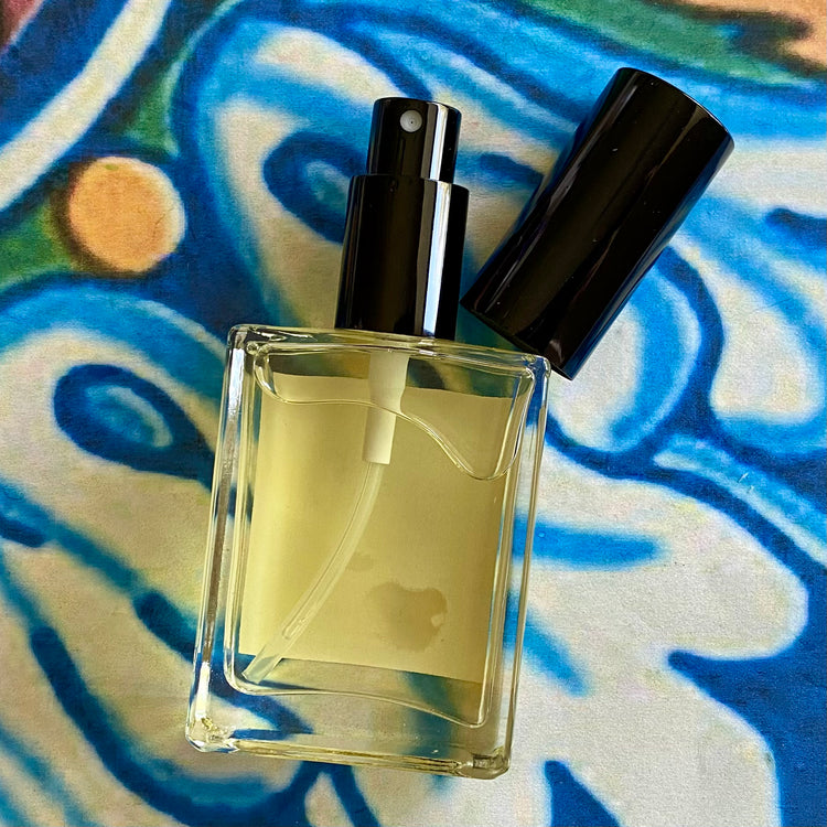 Perfume bottle filled with yellow liquid on a colorful abstract background