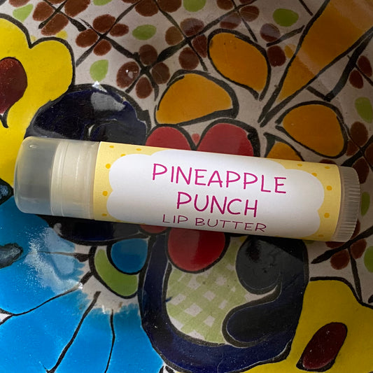 Lip butter labeled 'Pineapple Punch' on a colorful floral plate