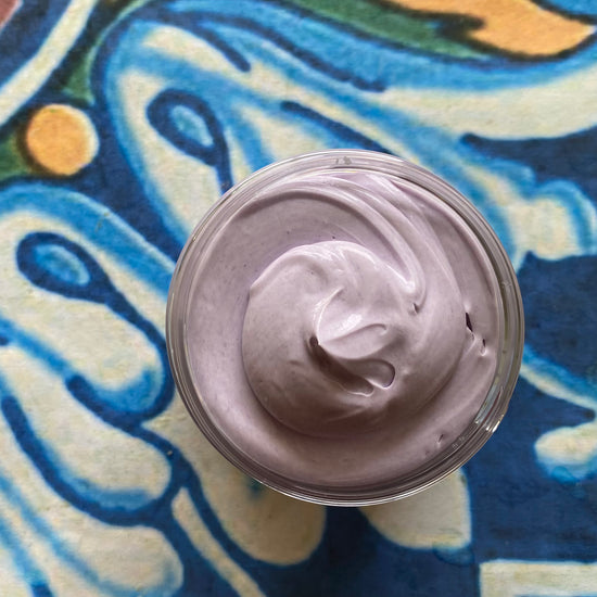 Jar of purple cream on a colorful abstract background