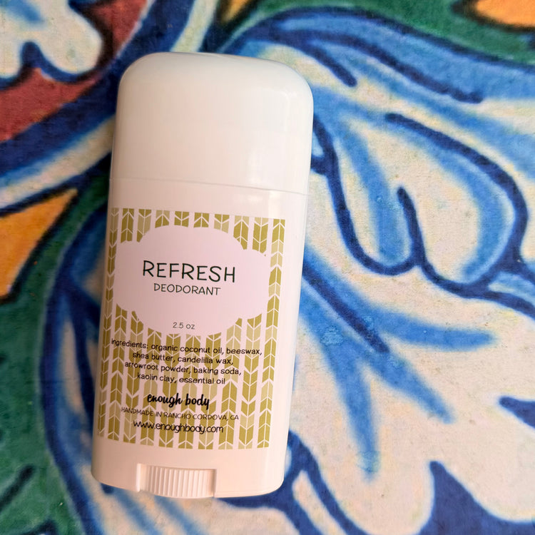 White deodorant stick with 'Refresh' branding on a colorful abstract background
