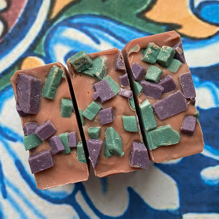 rectangular soap top with green and purple chunks on a colorful tile background