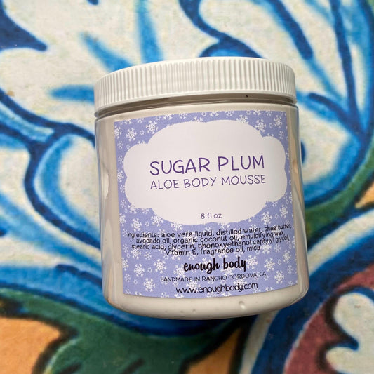 Jar of Sugar Plum Aloe Body Mousse with a colorful abstract background
