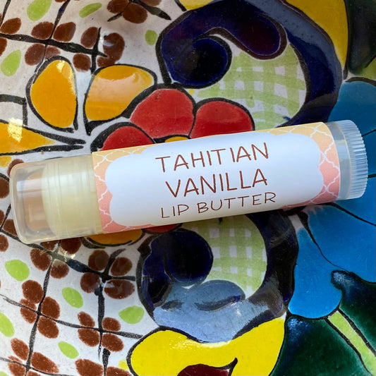 A tube of tahitian vanilla lip butter on a colorful background