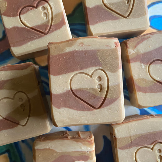 Multi colored brown bars of soap with heart designs on a colorful abstract background