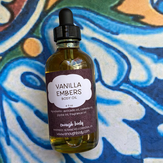 Bottle of Vanilla Embers body oil with a dropper top on a colorful background