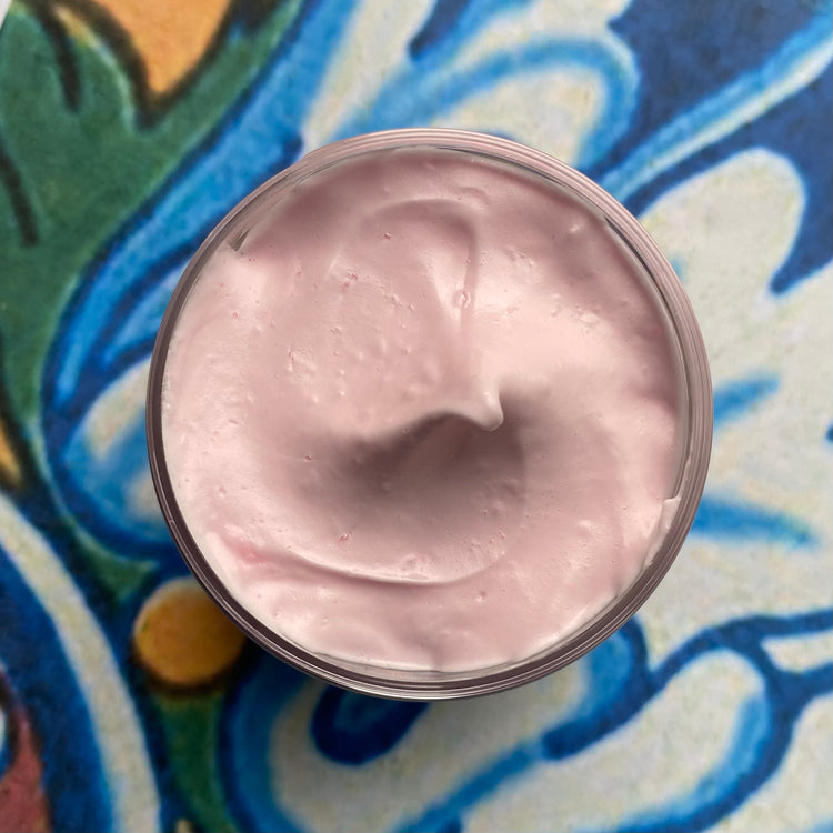 Pink cream in a jar on a colorful patterned surface
