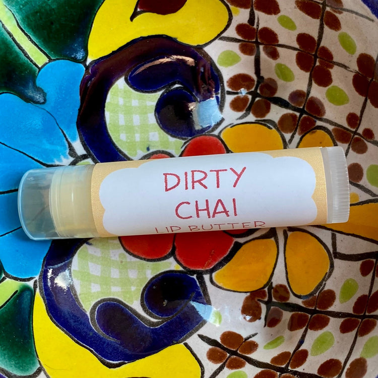 A tube of dirty chai lip butter on a colorful background