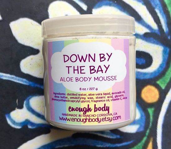 Jar of down by the bay Aloe Body Mousse on a colorful background