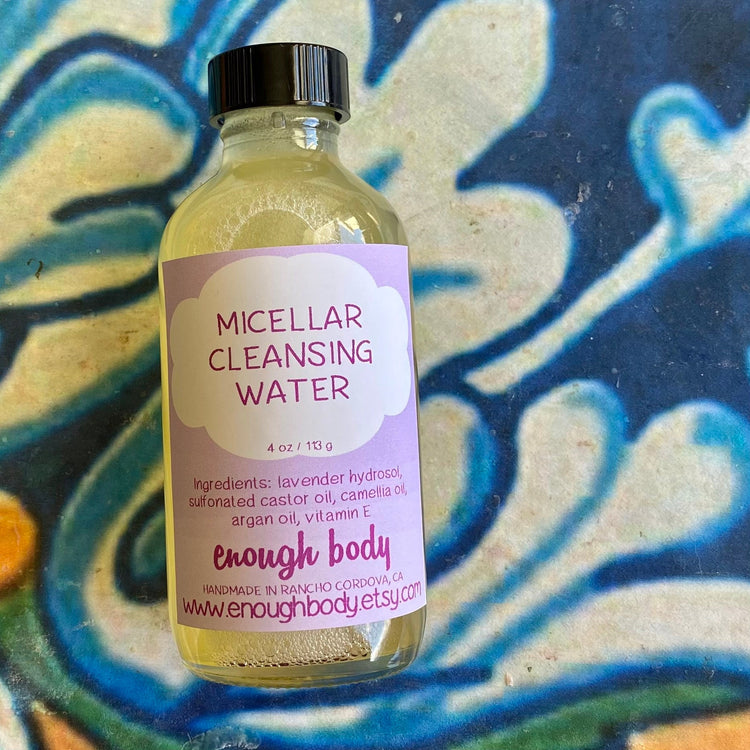 Bottle of micellar water with purple label on a colorful abstract background