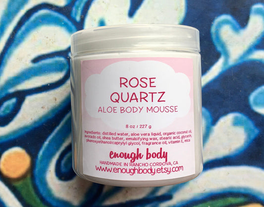 A jar of Rose Quartz Aloe Body Mousse with a pink label, indicating the product is an aloe-based moisturizer.
