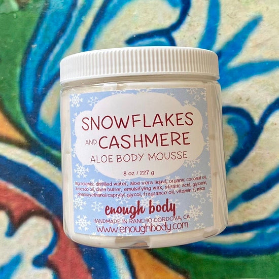 Jar of snowflakes and cashmere Aloe Body Mousse on a colorful background
